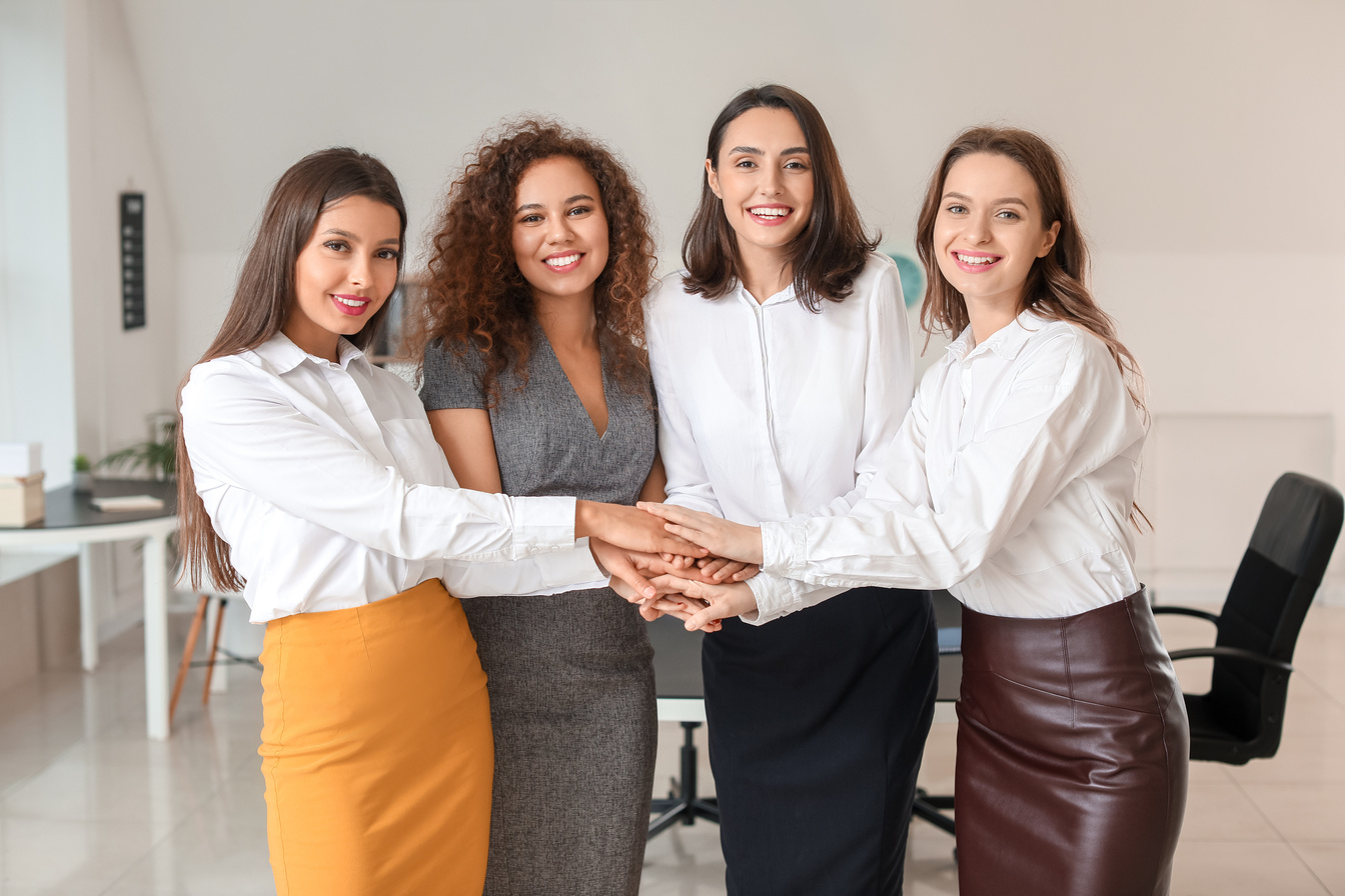 Young Women Putting Hands Together in Office